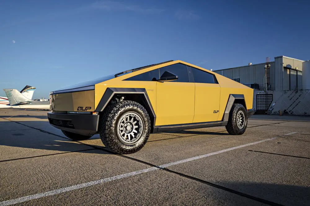 Dune Sand Vinyl Wrapped Cybertruck with Carbon Fiber Fenders, INVINCIBLE Rear Steel Bumper with Swing Arms on 18 inch UP-03 Forged Beadlock Wheels in Satin Titanium