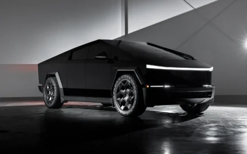 Tesla Cybertruck showcasing 24-inch Cybrhex Wheels in Satin Black by Unplugged Performance, parked in a sleek industrial space, emphasizing futuristic design and off-road capability.