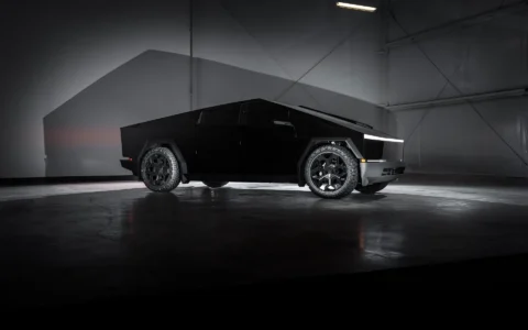 Tesla Cybertruck showcasing 24-inch Cybrhex Wheels in Satin Black by Unplugged Performance, parked in a sleek industrial space, emphasizing futuristic design and off-road capability.